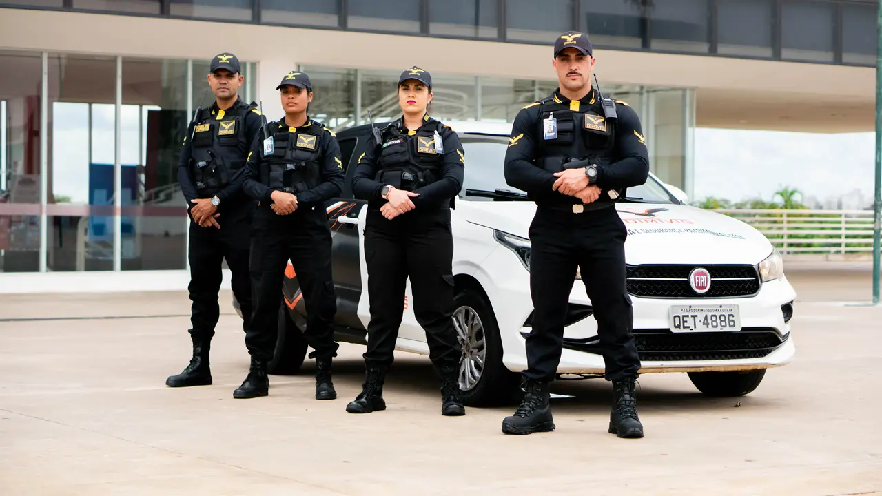 Equipe de vigilantes da DIMIVIG ao lado de viatura